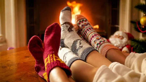 Zbliżenie obrazu rodziców i dziecka stóp w ciepłe wełniane skarpety, leżącego obok kominki — Zdjęcie stockowe