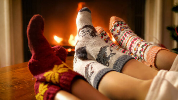 Toned image of family relaxing by the fireplace on Christmas eve