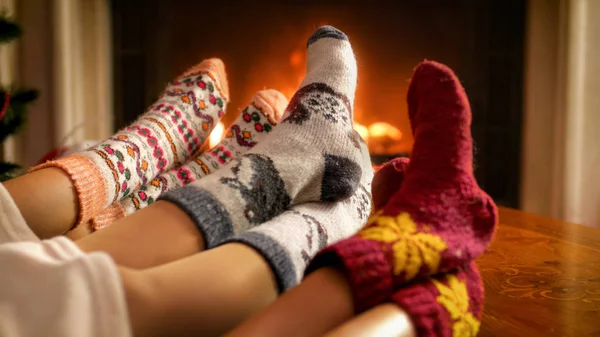 Imagen de cerca de la familia en calcetines de punto de lana que yacen en la sala de estar con chimenea —  Fotos de Stock