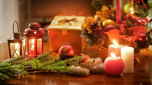 Φωτογραφία: closeup Χριστουγεννιάτικο στεφάνι, καύση κεριά και δώρου στο ξύλινο τραπέζι — Φωτογραφία Αρχείου