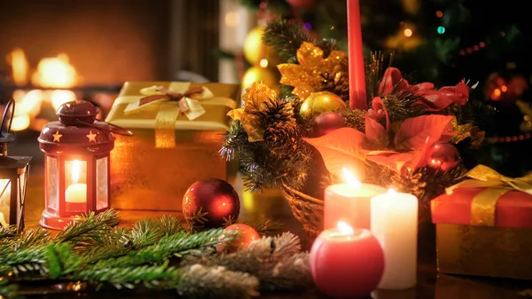 Imagem de close-up de grinalda tradicional, caixas de presente e lanternas contra árvore de Natal e lareira — Fotografia de Stock