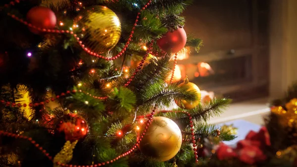 Closeup image of Christmas tree branches with hanging golden and red baubles on them — Stock Photo, Image