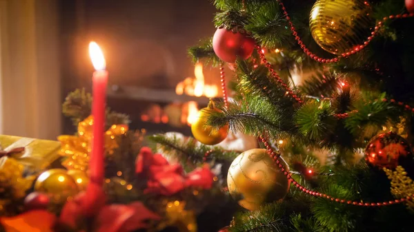Imagem de close-up de ramos de árvore de Natal contra velas e lareira em chamas — Fotografia de Stock