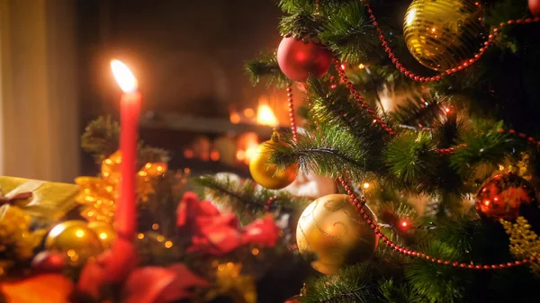 Imagem close-up de belas bugigangas douradas e vermelhas penduradas em galhos de árvore de Natal — Fotografia de Stock