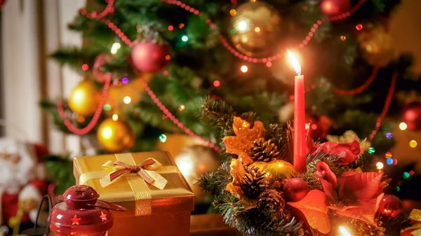 Zbliżenie zdjęcie dekoracyjny wieniec bożonarodzeniowy z płonącą świecą w salonie — Zdjęcie stockowe