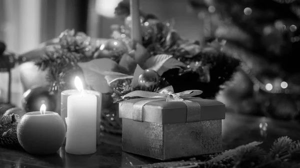 Image en noir et blanc de bougies, cadeaux et boules contre l'arbre de Noël — Photo