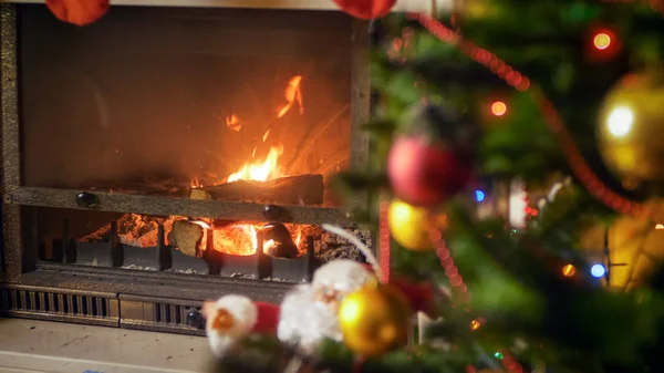 Burning fireplace in living room next to decorated Christmas tree — Stock Photo, Image