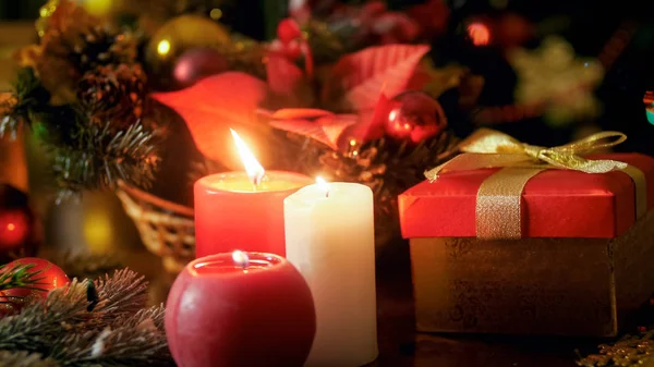 特写照片三燃烧蜡烛和金色礼品盒与丝带弓。冬季假期和庆典的完美 backgorund — 图库照片