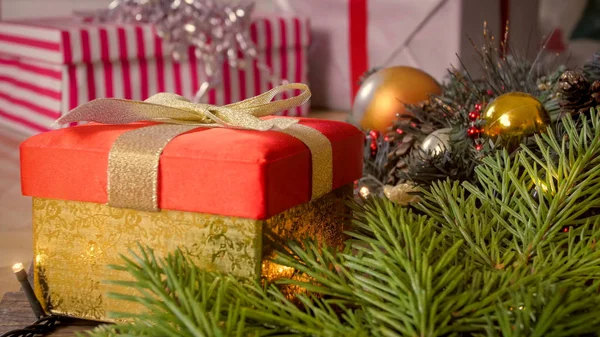 Detailní snímky zlaté krabičky s stuhou luk s vánoční výzdobou na dřevěnou podlahu — Stock fotografie