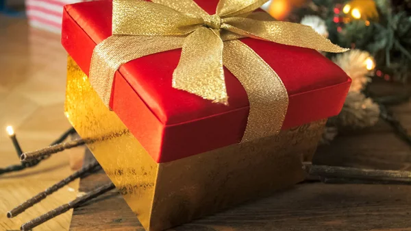 Detailní Foto červená Vánoční dárková krabice s mašlí zlatá stuha na dřevěné backgrouind — Stock fotografie