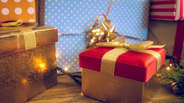 Vértes tónusú fénykép a sok-sok karácsonyi ajándék, fényes színes csomagolópapír és dobozok — Stock Fotó