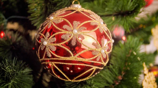 Kloakkbilde av skinnende rødt bomullsskinn med gyllent glitter på juletregrenen – stockfoto