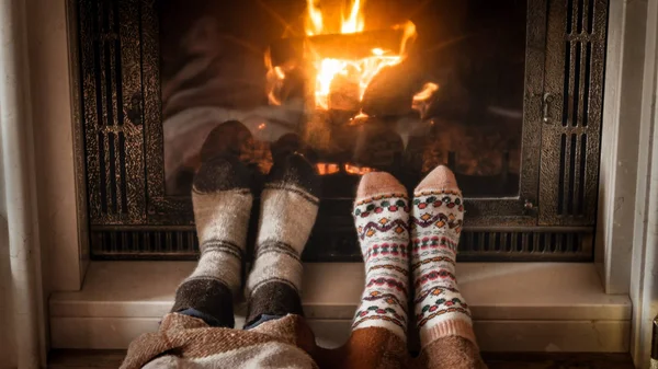 Closeup image of feet in woolen socks lying by the fireplace — Stock Photo, Image