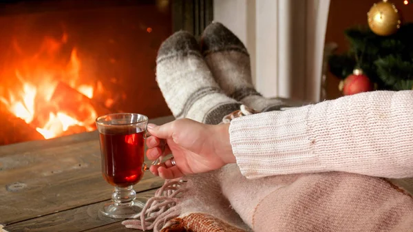 Imagen de cerca de la mujer bebiendo vino caliente en la sala de estar y la chimenea — Foto de Stock