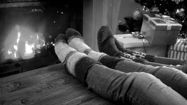 Citra hitam dan putih keluarga bersantai di perapian pada malam Natal — Stok Foto