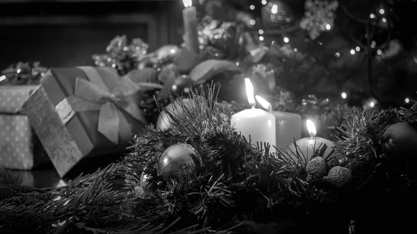 Μαύρο και λευκό εικόνα του αναμμένα κεριά κατά το χριστουγεννιάτικο δέντρο και τα δώρα — Φωτογραφία Αρχείου