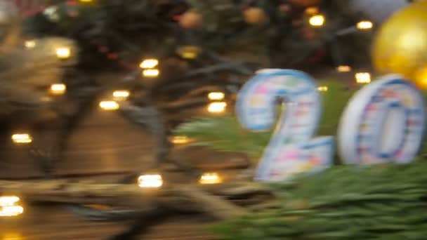 Imagens de close-up 4k da câmera se movendo ao longo da mesa de madeira e parando nas velas de Natal de 2018 — Vídeo de Stock