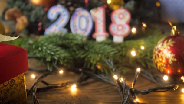Closeup 4k beelden van de camera beweegt richting 2018 Nieuwjaar kaarsen op houten tafel — Stockvideo