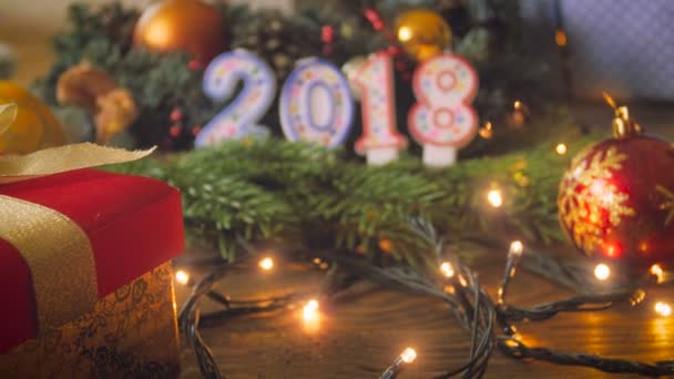 Primer plano imágenes de 4k de la cámara moviéndose lentamente sobre la mesa de Navidad decorada hacia las velas de Año Nuevo 2018 — Vídeo de stock
