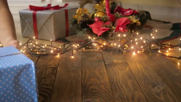 4 k βίντεο κάμερα αργά κινούνται πάνω από την ξύλινη επιφάνεια προς το χριστουγεννιάτικο δέντρο. Άνθρωποι βάζοντας δώρα στα πλαίσια — Αρχείο Βίντεο