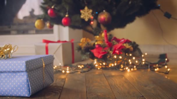 Tonificado primer plano 4k metraje de los padres poniendo regalo bajo el árbol de Navidad por la noche — Vídeos de Stock