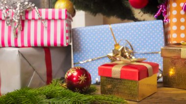 Baubles, parlayan çelenk ve hediye kutuları oturma odası, Noel ağacının altında closeup 4k görüntüleri