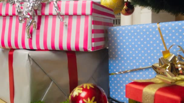 Imágenes de primer plano de la cámara moviéndose lentamente a lo largo de un gran montón de regalos de Navidad y regalos en la sala de estar — Vídeos de Stock