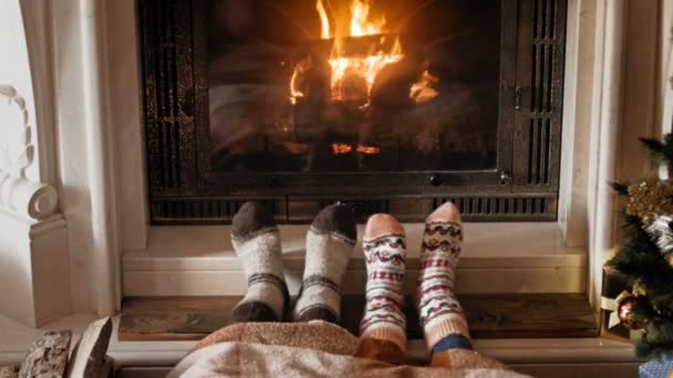 4k metraje de pareja romántica en calcetines de calentamiento en la chimenea en llamas — Vídeo de stock