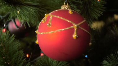 Closeup ağır çekim görüntüleri dönen kırmızı biblo Noel ağacı dalı