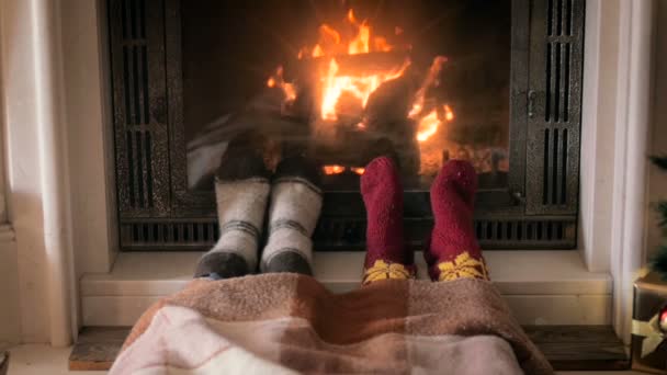 Vidéo à faible mouvement des pieds chauffants de la famille à la cheminée en feu — Video