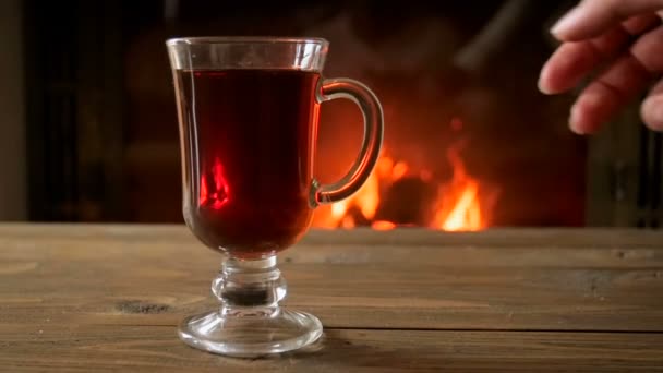 Zeitlupenaufnahmen einer weiblichen Hand, die einen Becher mit Glühwein vom Holztisch nimmt — Stockvideo