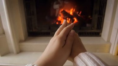 Genç kadının elleri yanan ateşi soğuk kış gününde, ısınma portre görüntüleri