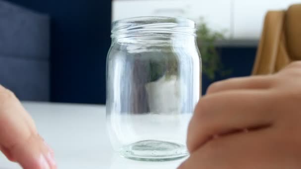 Close-up 4k imagens de jovem casal pegou título Poupança no frasco de vidro — Vídeo de Stock