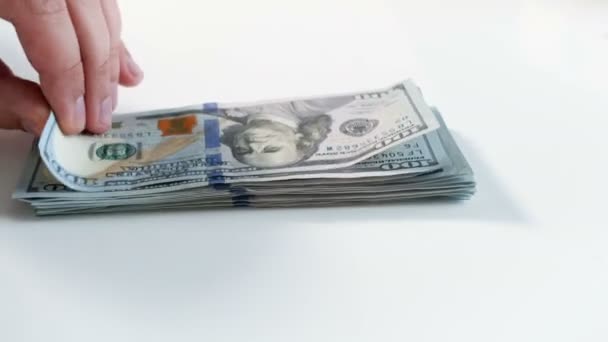 Imagens de close-up 4k de duas pessoas agarrando montes de dinheiro deitado em uma mesa branca. Conceito de despender dinheiro — Vídeo de Stock