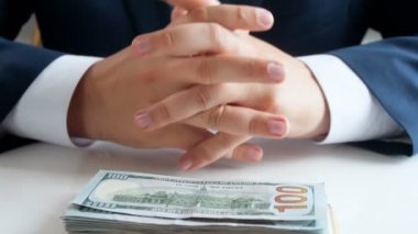 4 k görüntülerini bize dolar yığını masanın üzerine düşüyor. Para katlama ve cebine koyarak genç işadamı