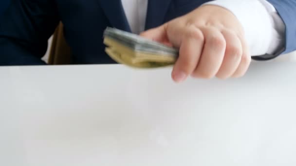 4k imagens de criminoso em terno colocando dinheiro e arma na mesa no escritório — Vídeo de Stock