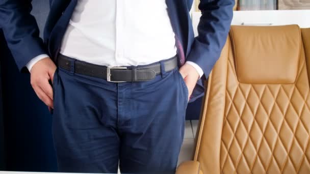 4k footage of businessman standing at office and taking one coin from pants pocket — Stock Video