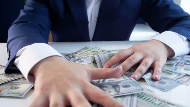 Slow motion video chciwy biznesmen grabing mnóstwo pieniędzy leżąc na biurku — Wideo stockowe