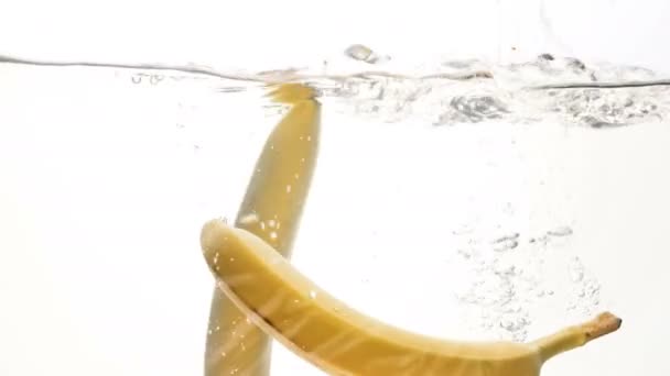 Closeup 4k beelden van drie gele bananen vallen in water — Stockvideo
