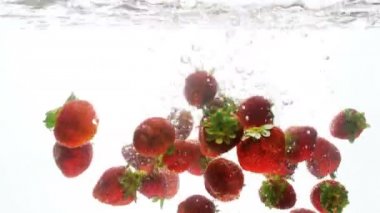 Closeup taze çilek beyaz arka plan suya düşen 4k video