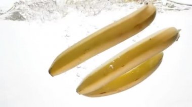 Thre olgun muz soğuk suya düşen closeup ağır çekim video