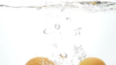 Odak odak görüntüleri beyaz arka plan suya düşen sulu olgun narenciye dışında ağır çekim