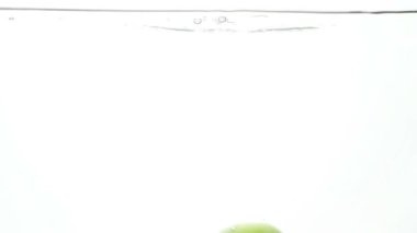 Beyaz arka plan karşı soğuk açık suda düşen bir taze olgun elma closeup ağır çekim görüntüleri