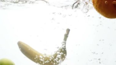 Bulanık Closeup ağır çekim video düşen ve beyaz arka plan karşı su sıçramasına tropikal meyveler