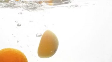 Closeup yüksek hızlı görüntüleri düşen ve beyaz arka plan karşı su sıçramasına tropikal sulu narenciye