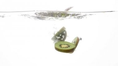 Beyaz arka plan açık soğuk suda düşen kesilmiş olgun kivi closeup ağır çekim video