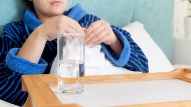 Genç kadın duygu hasta, yatakta yatan ve hapları içme görüntülerini closeup 4k