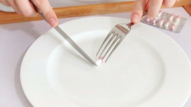 Kavramsal 4 k görüntüleri hapları kilo vermek için. Eller çatal ve bıçak ile aliminin kilo kaybı için yemek
