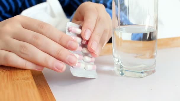 Closeup 4k beelden vrouw nemen van pillen uit de blisterverpakking en drinken met glas water — Stockvideo