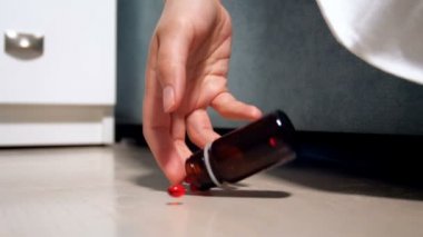 Yere düşen ilaç şişesi tutan el closeup ağır çekim video. İlaç aşırı doz veya intihar kavramı
